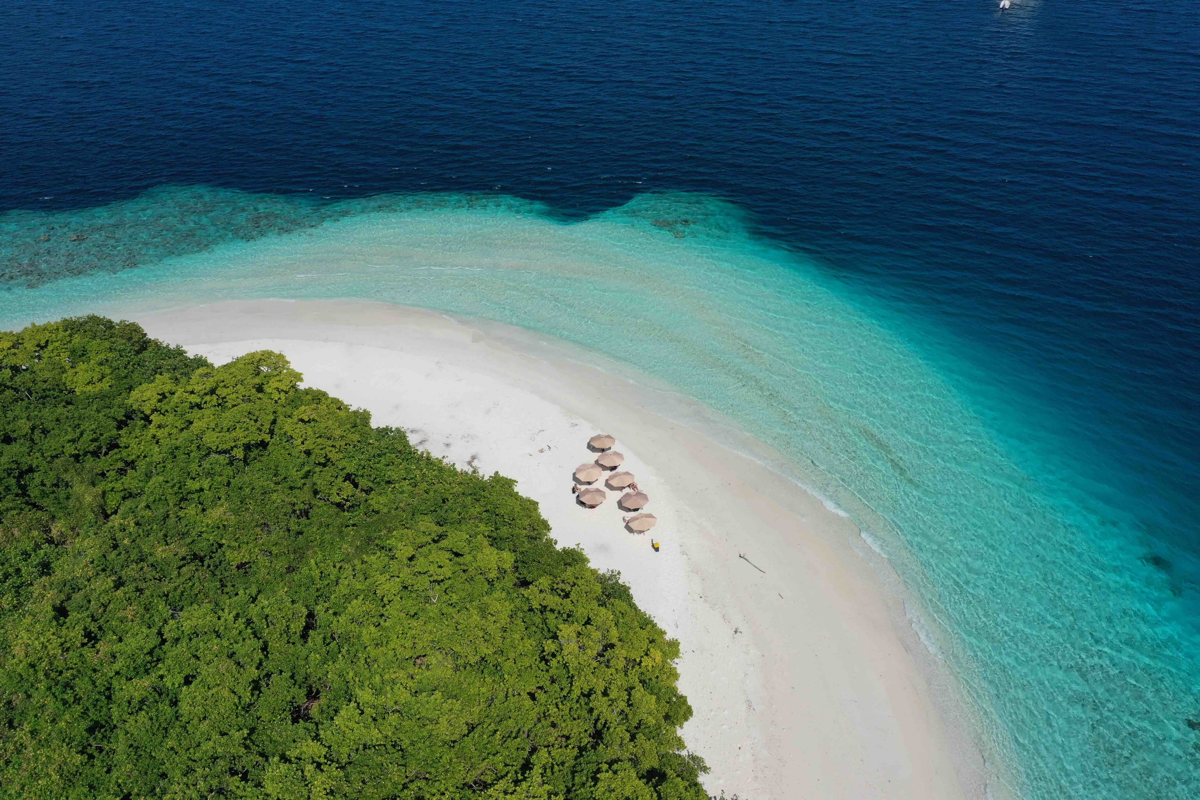 Aerial view of overwater villas beside a tropical island